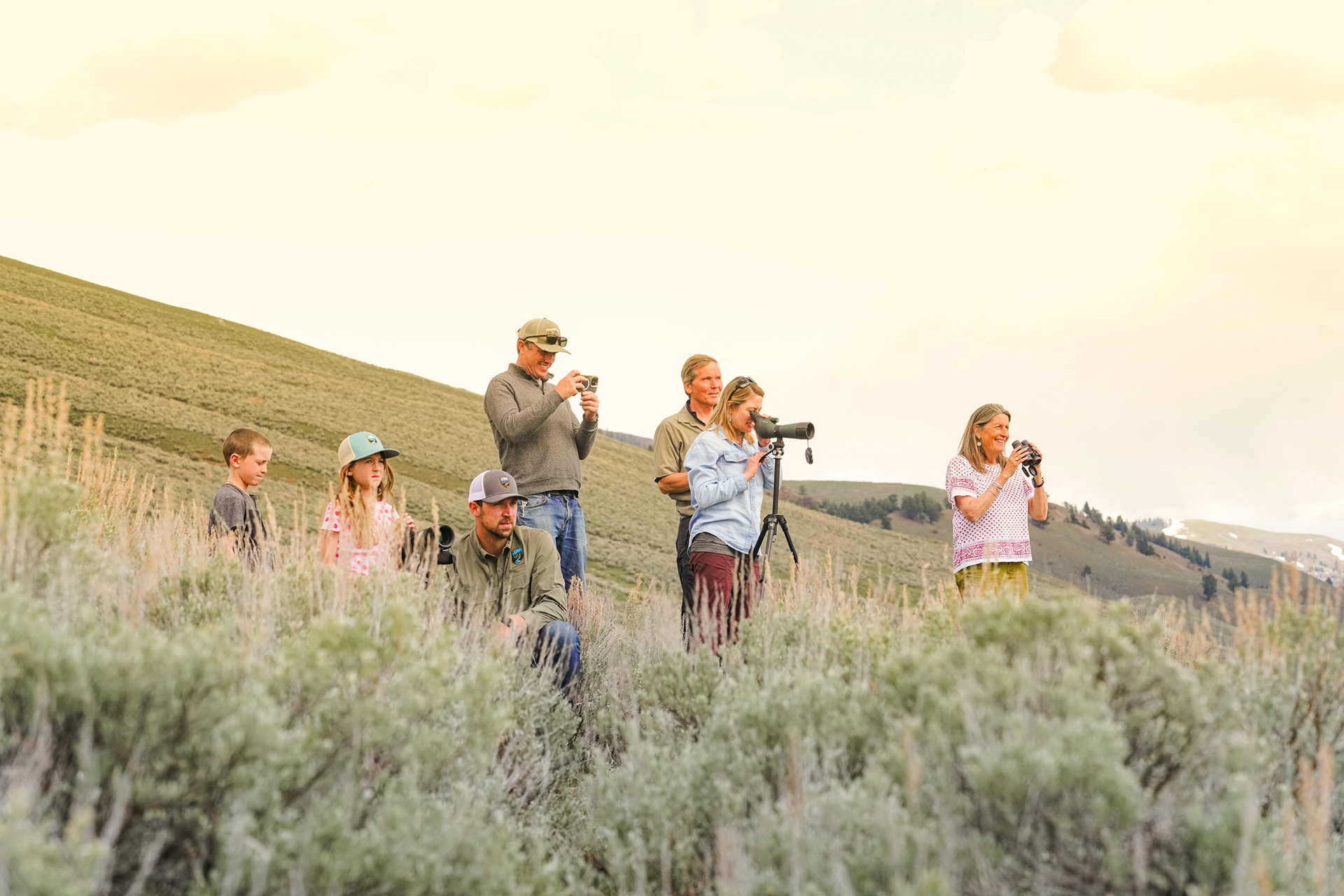 GWE_SummerTours_12 Two Kids with a guide looking for bison through a scope.